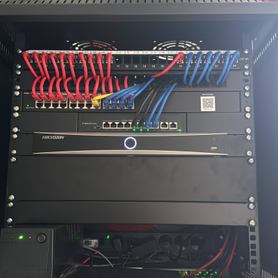 ארון תקשורת עם כבלים אדומים וכחולים מחוברים למתגים