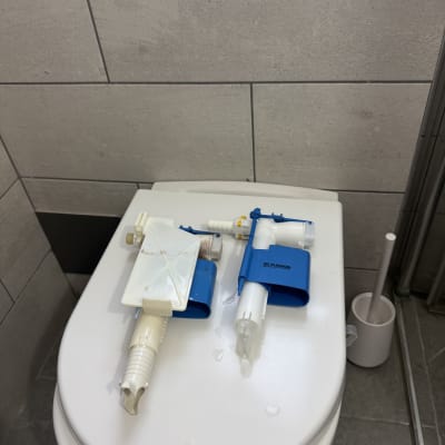 חלקי אינסטלציה על מכסה אסלה בחדר אמבטיה