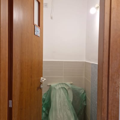 שירותים בשיפוץ עם כיסוי ירוק על האסלה