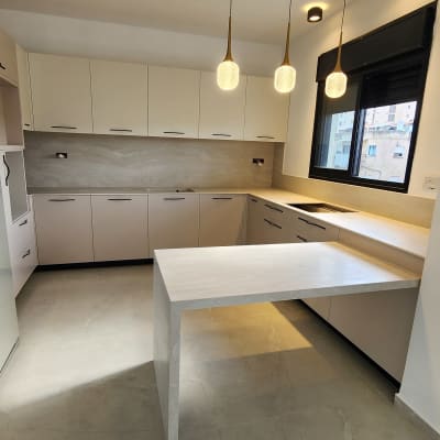 מטבח מודרני עם תאורה תלויה ושיש לבן