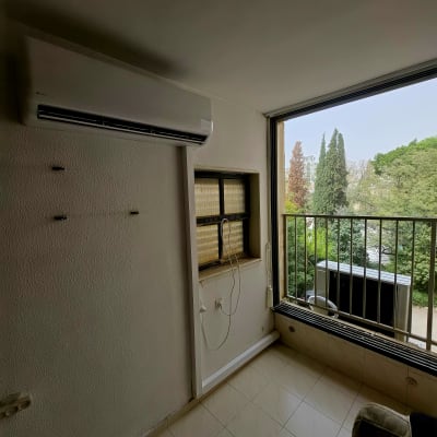 מזגן מותקן על קיר ליד חלון פתוח