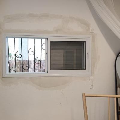 קיר עם חלון ומראה, סימני צבע על הקיר