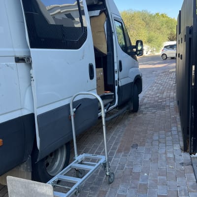 רכב מסחרי פתוח עם עגלת הובלה על מדרכה