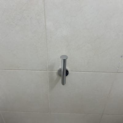 מתלה מגבת מתכת על קיר אריחים