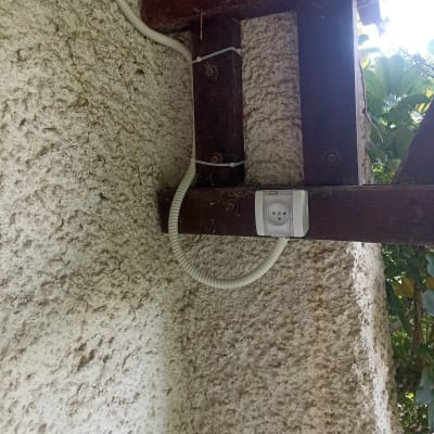 שקע חשמלי מותקן על קיר חיצוני עם כבלים