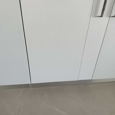 ארונות מטבח עם ידיות מתכת על רצפת אריחים