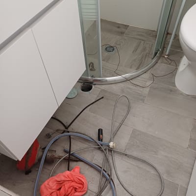 צינורות וכלי עבודה על רצפת חדר אמבטיה