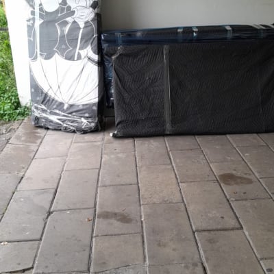 מזרנים עטופים בניילון מונחים על רצפה מרוצפת