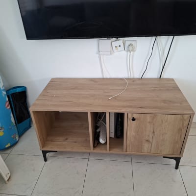 ארון עץ מתחת לטלוויזיה עם כבלים חשמליים