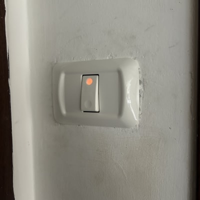 מתג חשמלי עם נורית חיווי על קיר