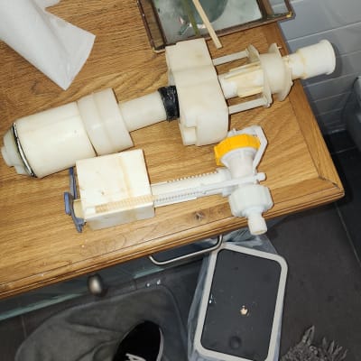 חלקי מנגנון אסלה מונחים על שולחן עץ