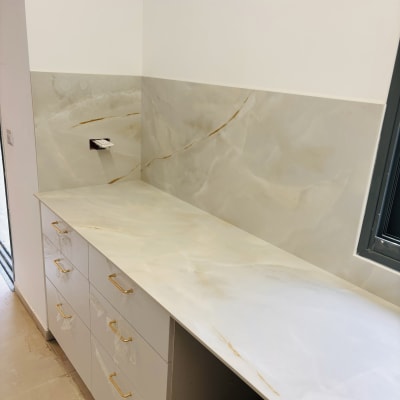 משטח שיש לבן עם גידים חומים במטבח מודרני