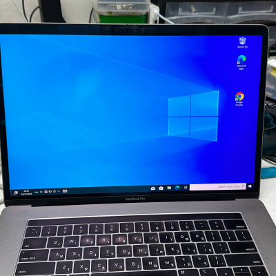 מחשב נייד עם מסך חלונות, כבלים ודיסק קשיח על שולחן עבודה