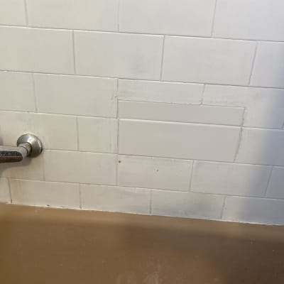 ברז מתכת על קיר אריחים לבנים