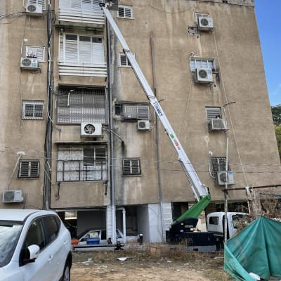 אדם על מנוף ליד גג בניין