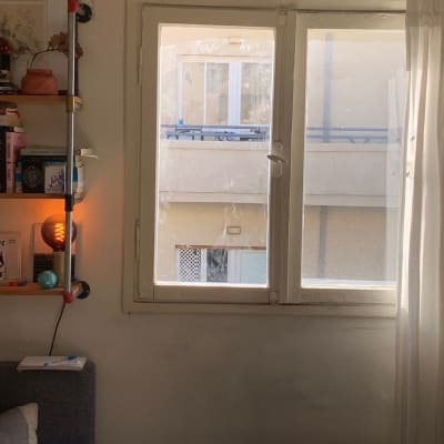 חלון זכוכית עם וילון לבן בצד ימין