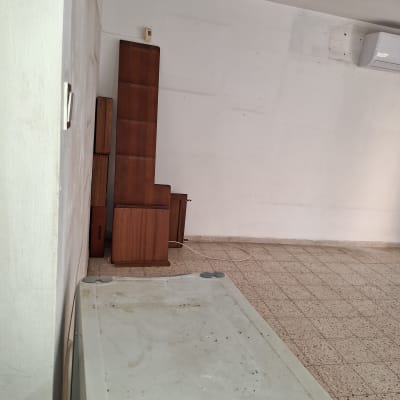 ארון עץ גבוה, שולחן פלסטיק מלוכלך, רצפת אריחים