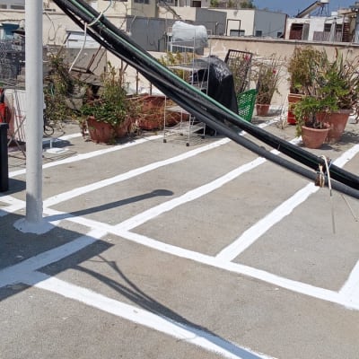 גג עם קווים לבנים לאיטום, צינורות ועציצים