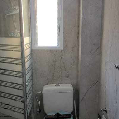 שירותים עם מגבת וכלי עבודה על האסלה