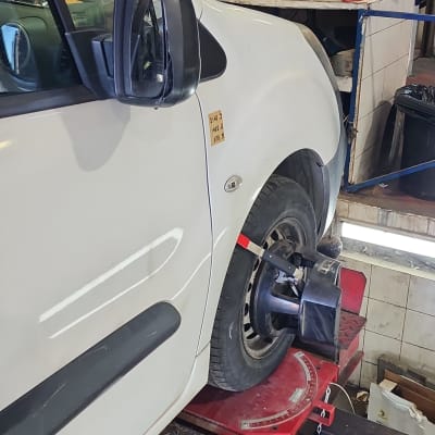 רכב על מכונת איזון גלגלים במוסך עם מסך תצוגה