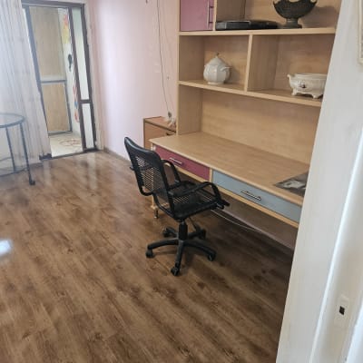 חדר עם רצפת עץ, שולחן וכיסא משרדי