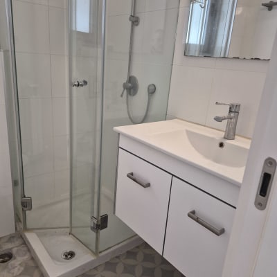 חדר אמבטיה עם מקלחון וכיור לבן