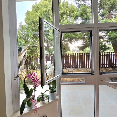 חלון אלומיניום פתוח עם מסגרת לבנה