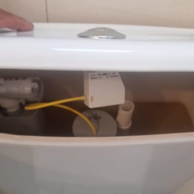 מיכל הדחה פתוח עם צינור צהוב ומנגנון פנימי