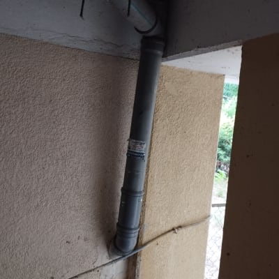 צינור פלסטיק אפור מחובר לקיר עם תושבות מתכת