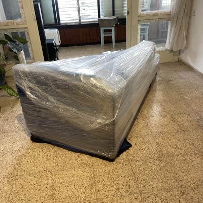 ספה עטופה בניילון לקראת מעבר דירה