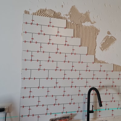 התקנת אריחים על קיר עם חוצצים אדומים