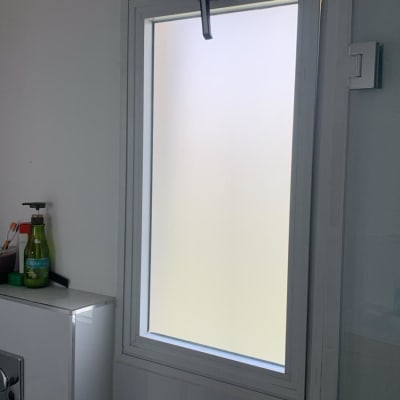 חלון זכוכית עם מסגרת לבנה בחדר אמבטיה