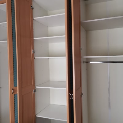 ארון עץ פתוח עם מדפים ריקים ומתלה בגדים