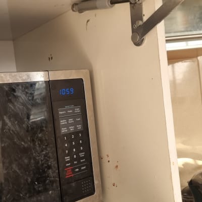 מוט מתכת ומנגנון קפיצי בארון מטבח