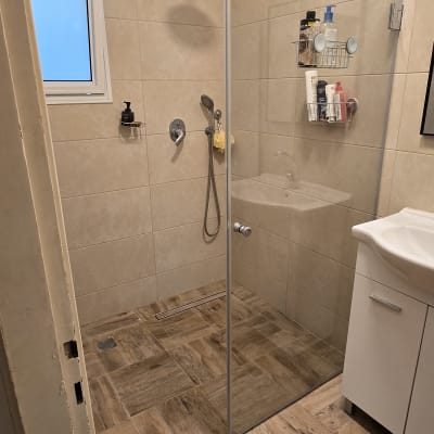 מקלחון עם ראש מקלחת, מדף עם מוצרי טיפוח