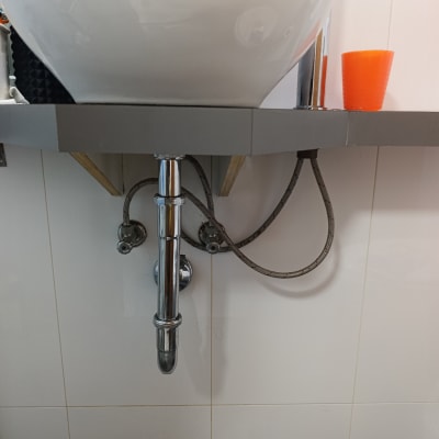 כיור עם צנרת מתחת ומדף