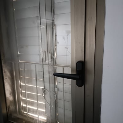 חלון זכוכית עם ידית שחורה ומסגרת מתכתית