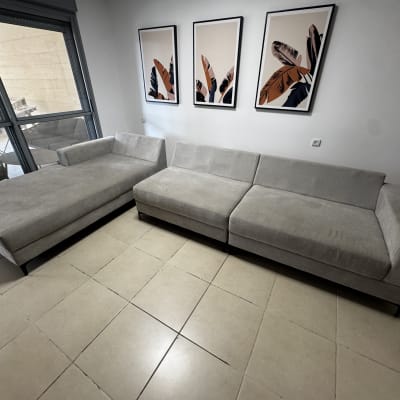 ספות אפורות בחדר עם תמונות על הקיר