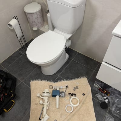 חלקי אסלה וכלים על רצפת חדר אמבטיה