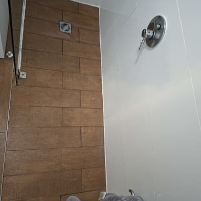 מקלחת עם אריחים חומים וברז כסוף