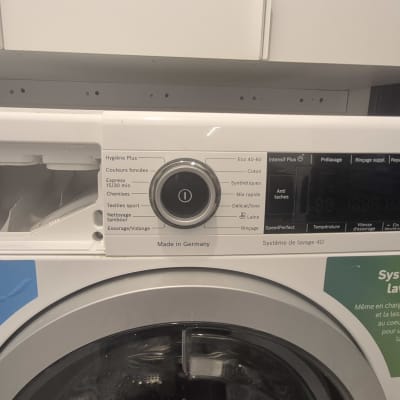 מכונת כביסה עם לוח בקרה ותוויות באנגלית וצרפתית