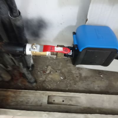 שסתום מים עם ידית אדומה ומכשיר כחול