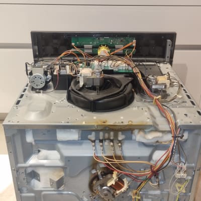 מכשיר חשמלי פתוח עם חוטים ורכיבים פנימיים גלויים