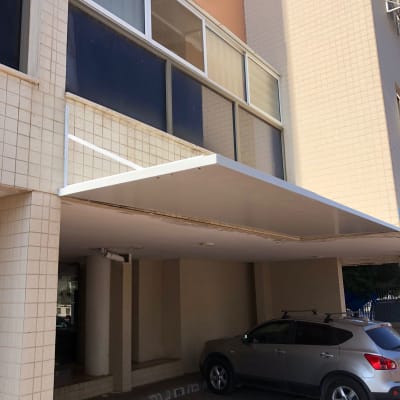 סוכך לבן מותקן מעל כניסה לבניין