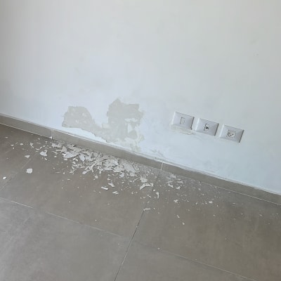 קיר עם טיח מתקלף ושקעים חשמליים