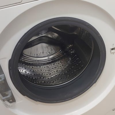 מכונת כביסה עם דלת פתוחה ולוח בקרה