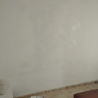 קיר צבוע חלקית עם דלי צבע ומברשת