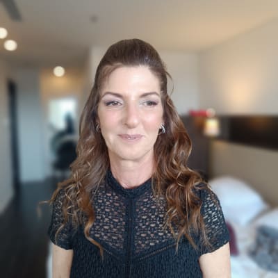 אישה עם שיער גלי ואיפור עיניים עדין