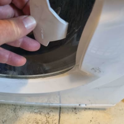 יד מחזיקה חלק של מכונת כביסה