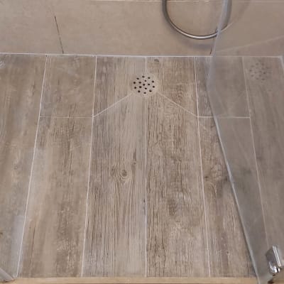 רצפת מקלחת עם אריחים ודלת זכוכית